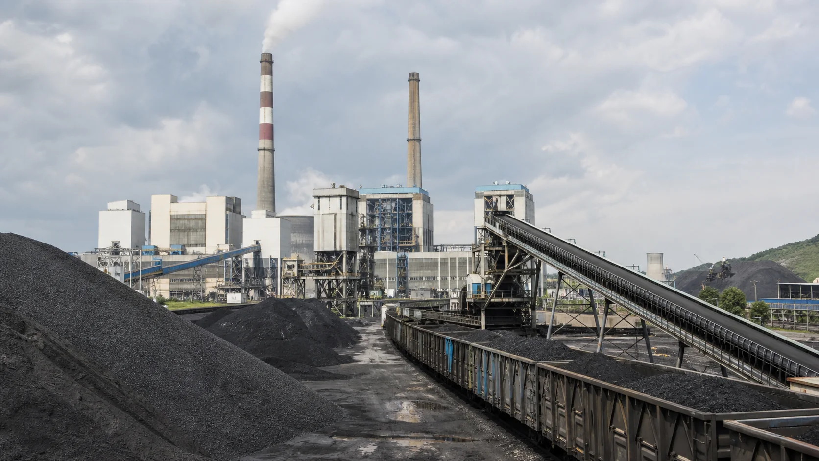 Thermal power plant coal yard with rail wagons, conveyors and plant buildings for fuel management review